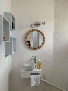 uma casa de banho com um lavatório e um espelho em Maison de pecheur em Trouville-sur-Mer
