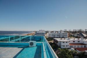 a balcony with a view of the beach and buildings at Apart Hotel Punta Azul in Punta del Este