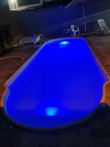 a large blue swimming pool in a dark room at Casa temporada Itanhaem in Itanhaém