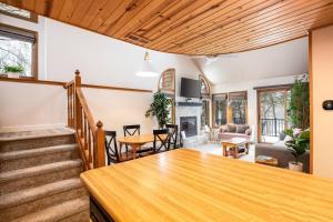a living room with a staircase and a dining room at Peaceful 2-bedroom townhome retreat w/wooded view in Galena