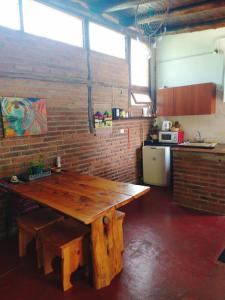 a wooden table in a kitchen with a brick wall at Cabaña en Villa General Belgrano in Villa General Belgrano