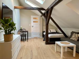 a attic bedroom with a bed and a table at Apartamenty Delecta in Krakow
