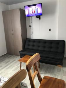 a living room with a black couch and a tv at APARTAESTUDIO Parque Olaya Pereira in Pereira