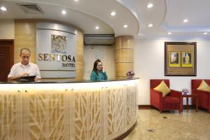 un hombre y una mujer de pie en un bar en Hotel Sentosa, en Kuala Belait