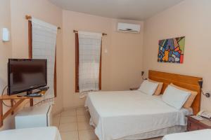 a small bedroom with two beds and a television at Casa Blanca in Ciudad del Este