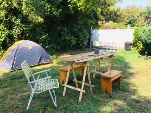 a picnic table and two chairs and a tent at Hostel Raíz in Pucón