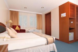 um quarto de hotel com uma cama e uma cadeira em Hotel Sentosa em Kuala Belait