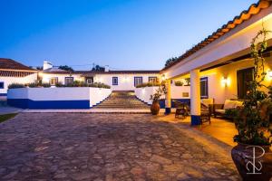 a villa with a courtyard at night at Quinta do Poço Novo in Alcáçovas
