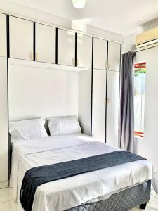 a bedroom with a bed with white sheets and cabinets at Awesome Sea views! House near Zimbali in Densainagar