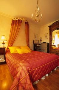 1 dormitorio con 1 cama grande con manta roja en Autrefois La Modiste, en Saint-Clar