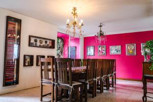 a dining room with a pink wall at Casa de las Bugambilias B&B in Oaxaca City