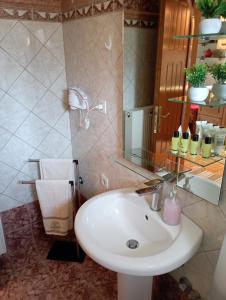 a bathroom with a white sink and a mirror at Prespes Lake View Family Apartment in Florina
