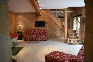 a living room with a couch and a tv at MOULIN DE L'HOSTE in Larzac