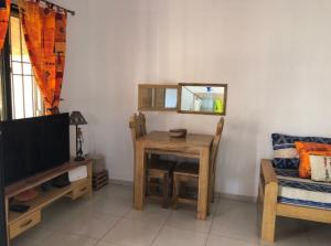 a living room with a table and a mirror at Maison Aziz - Somone - Sénégal in Somone