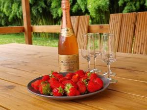 a bottle of champagne and strawberries on a table at MOULIN DE L'HOSTE in Larzac
