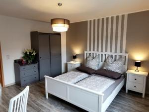 a bedroom with a white bed and two night stands at Ferienwohnung Kathlower Mühle in Neuhausen