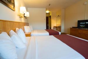 Tempat tidur dalam kamar di Canadas Best Value Inn- Riverview Hotel