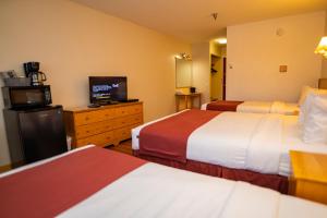 Habitación de hotel con 2 camas y TV de pantalla plana. en Canadas Best Value Inn- Riverview Hotel en Whitehorse