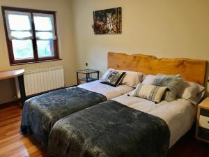 dwa łóżka ustawione obok siebie w pokoju w obiekcie Caserio Arrigorri excelente ubicación jardín con barbacoa 14 plazas w mieście Murguía