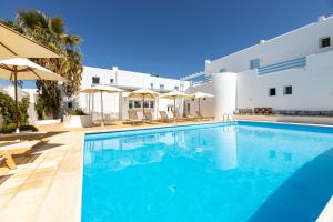 - une piscine avec des chaises et des parasols à côté d'un bâtiment dans l'établissement Villa Irena Bianca, à Náoussa