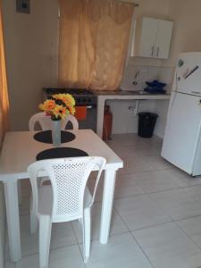 a kitchen with a table and two chairs and a refrigerator at Hospedaje Maluli Suit 5 in Santa Elena