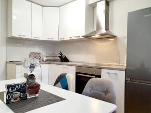 a kitchen with white cabinets and a table with a dog box on it at Apartment Nedim in Mostar
