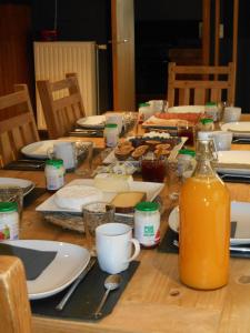 uma mesa com pratos e uma garrafa de sumo de laranja em B&B A l'Ombre du Tilleul em Aywaille