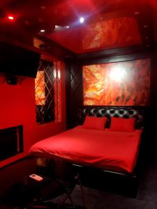 a red room with a bed with a painting on the wall at "DREAM ROOM" Тематические апартаменты Харьков! Цоколь! in Kharkiv