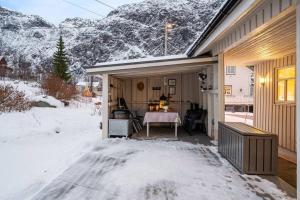 eine überdachte Terrasse mit einem Tisch im Schnee in der Unterkunft Lyngen View House in Koppangen