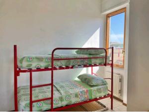 Ce dortoir comprend 2 lits superposés et une fenêtre. dans l'établissement Casa Nina, à Lido di Fermo