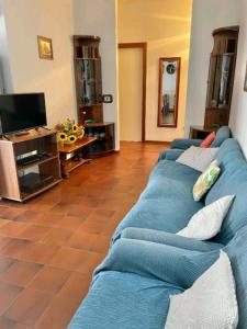 un salon avec un canapé bleu et une télévision dans l'établissement Casa Nina, à Lido di Fermo