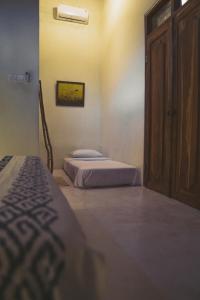 a bedroom with two beds and a wooden door at Adara Homestay in Banyuwangi