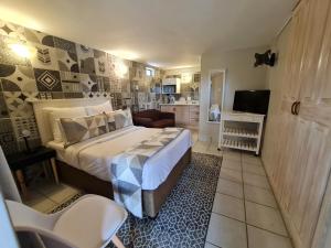 a small bedroom with a bed and a kitchen at THE THATCH HIDE in East London