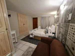 a bedroom with a bed and a couch in it at THE THATCH HIDE in East London