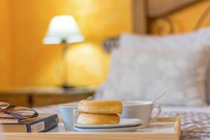 a tray with two donuts and a cup on a bed at El Mirador De Ruidera in Ruidera