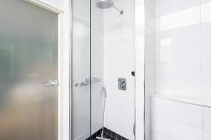 a bathroom with a shower with a glass door at Hiisi Hotel Helsinki Jätkäsaari in Helsinki