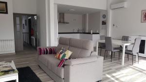 a living room with a couch and a table and a kitchen at Apartamentos Las Huertas in Villamiel