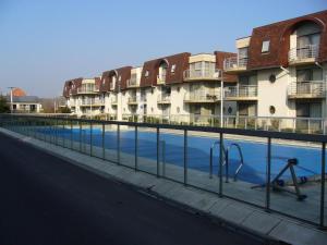 a swimming pool in front of some apartment buildings at Appartement Biaritz in Bredene