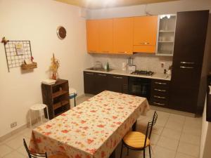 eine Küche mit einem Tisch und eine Küche mit orangefarbenen Schränken in der Unterkunft apartment vista legnone in Dubino
