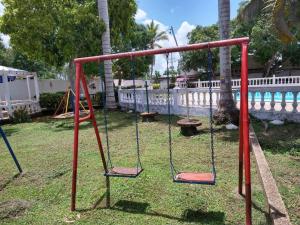 an empty swing set in a yard with a fence at Habitaciones Familiares Hacienda Botero in Turbaco +8 photos