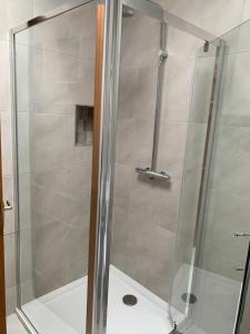 a shower with a glass door in a bathroom at Dingle Harbour Nights - Room Only in Dingle