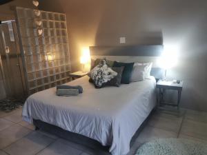 a bedroom with a large bed with pillows on it at Adams- mtoti in Pietermaritzburg