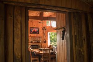 una puerta abierta a una habitación con mesa y sillas en Chalés Namaskar, en São Bento do Sapucaí