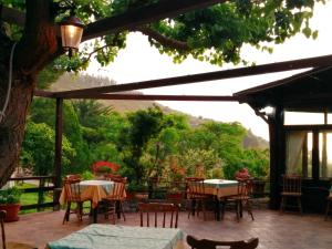 een patio met tafels en stoelen en een boom bij Casale Drinzi in Collesano