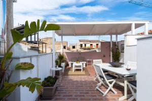 eine Terrasse mit einem Tisch und einem weißen Sonnenschirm in der Unterkunft Attico Sesto Canto in Palermo