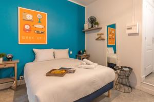 - une chambre dotée d'un lit avec un mur bleu dans l'établissement Apartments WS Hôtel de Ville - Le Marais, à Paris
