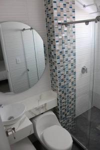 a bathroom with a toilet and a sink and a mirror at Hermosa Casa Grande De 3 Pisos Barranquilla in Barranquilla