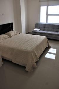 1 dormitorio con 1 cama y 1 sofá en Hermosa Casa Grande De 3 Pisos Barranquilla, en Barranquilla
