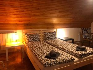 a bedroom with a large bed with a wooden wall at Kuća 1A, Kaluđerske Bare, Tara in Mala Reka
