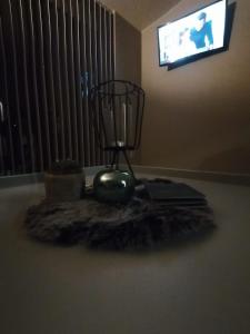 a room with a table with a fan and a television at Het Innerhof in Oudsbergen 